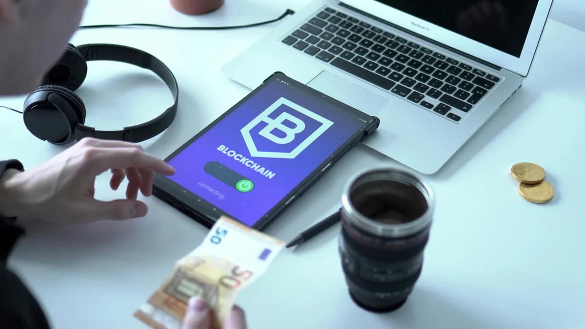 Blockchain Consensus: PoS, Smart Contract & Liquidity Pools Close-up of digital currency transaction using blockchain technology on tablet with laptop and euro bills.