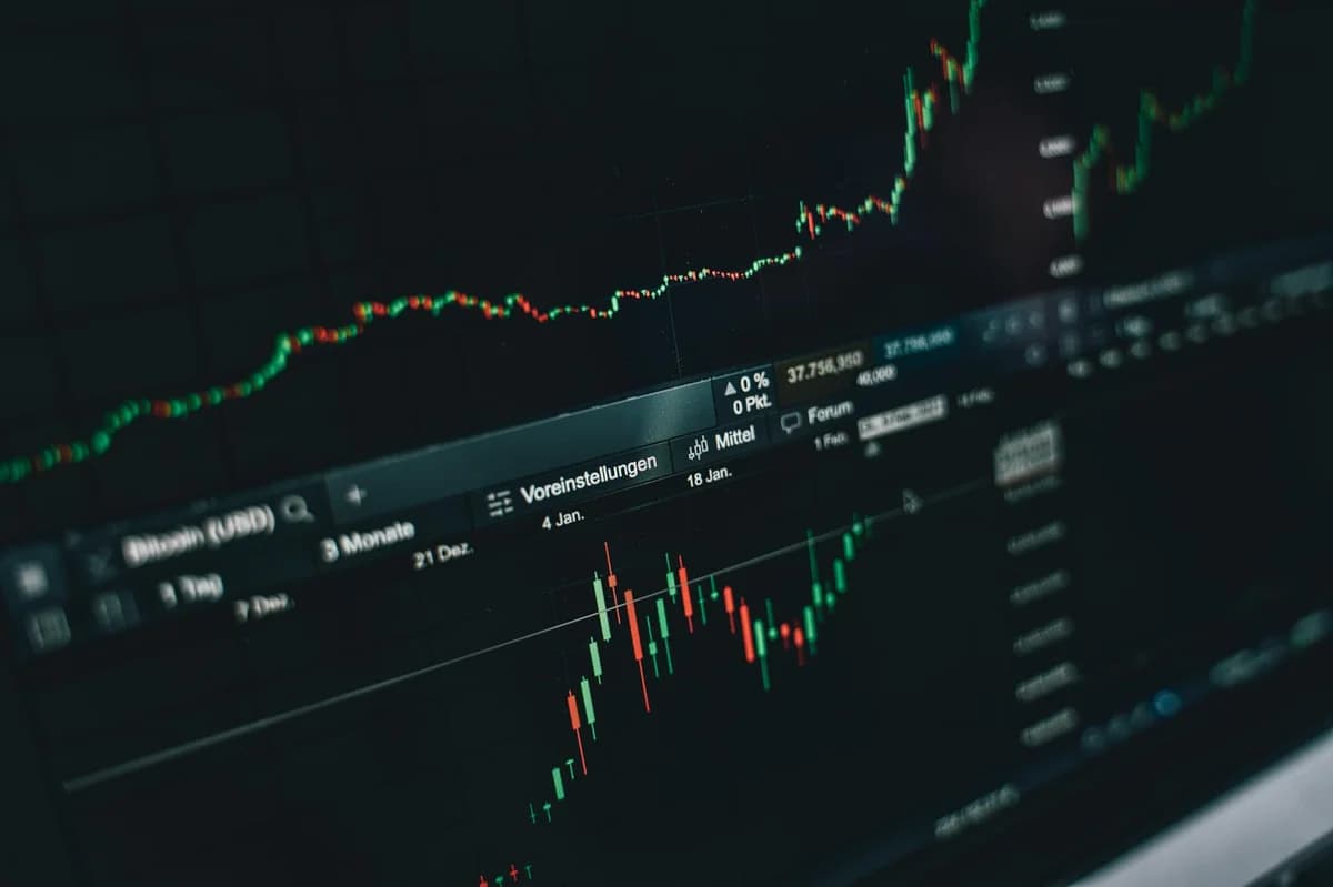 Bull Market vs Bear Market: A Crypto Beginner's Guide Smartphone displaying trading app with Bitcoin coins on a dark surface.